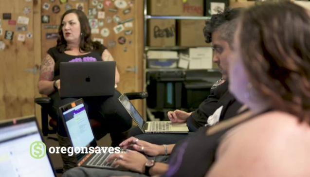 Rose City Oregon Saves video thumbnail people working at computer stations with woman standing in background